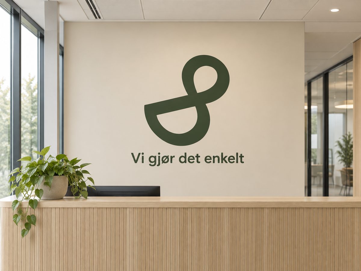 Logo og teksten «Vi gjør det enkelt» i grønn folie på veggen i en resepsjon