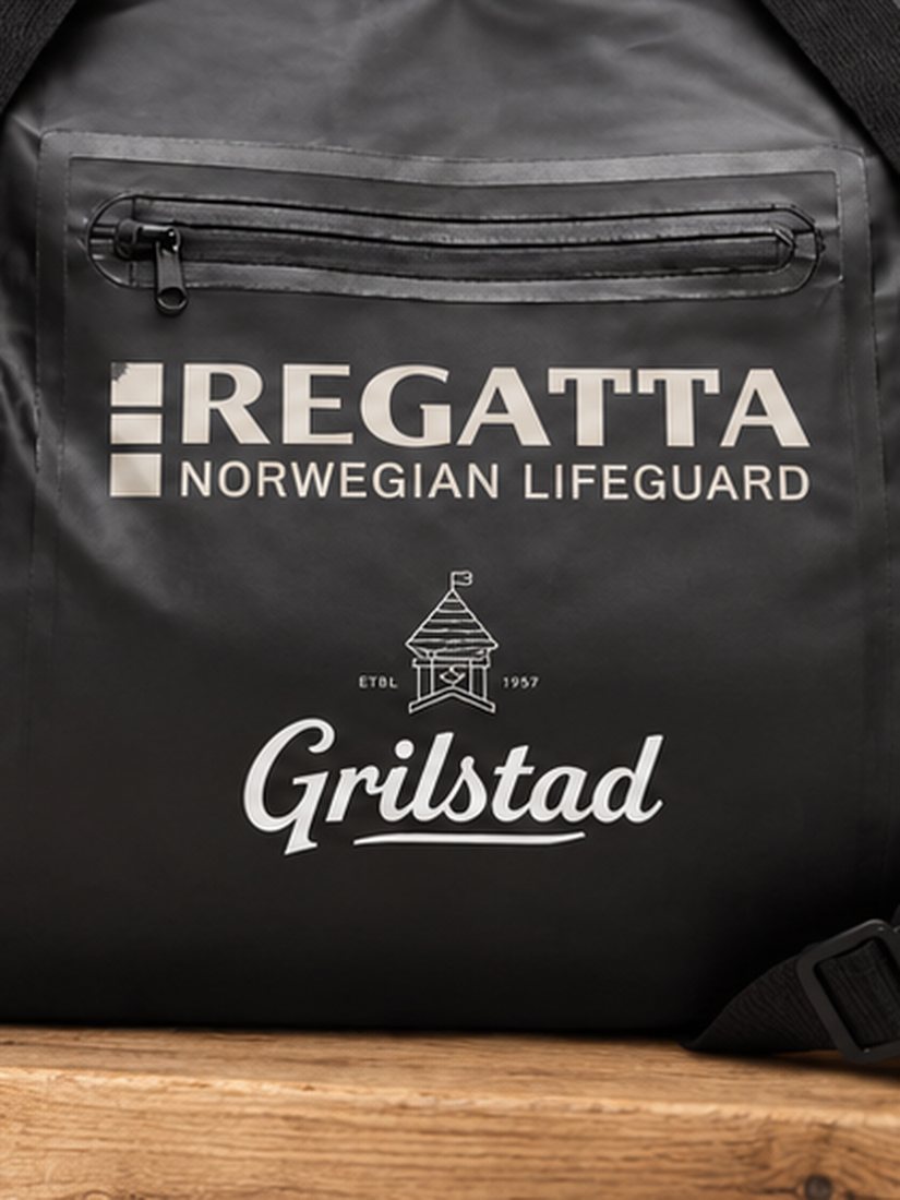 Nærbilde av hvit Grilstad-logo på sort bag